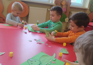 Dzieci układają z elementów sylwetę dinozaura