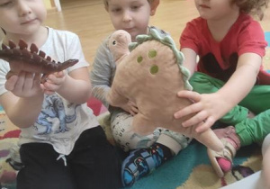 Dzieci prezentują przyniesione dinozaury.