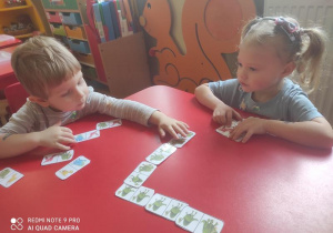 Wojtuś z Nikolą grają w domino z dinozaurami.