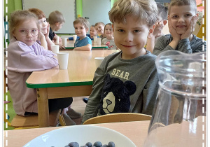 Dzieci poznają owoc borówki, która będzie wykorzystana do zrobienia soku z Gumijagód