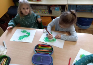 Hania Z. i Nela tworzą paszczę dinozaura.