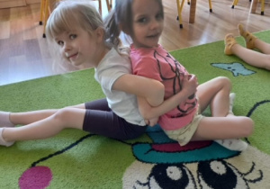 Idalia i Gabrysia wykonują ćwiczenie gimnastyczne.