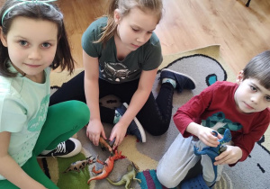 Michasia, Zosia i Maks bawią się dinozaurami