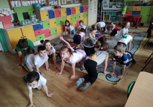 Dzieci wykonują ćwiczenia gimnastyczne z woreczkami