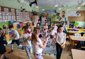 Dzieci wykonują ćwiczenia gimnastyczne z woreczkami