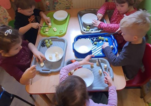 Dzieci przygotowują owoce do sałtki.