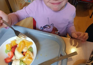 Nadia zajada sałatkę owocową.