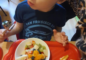 Tymon zajada sałatkę owocową.