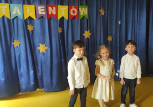 Dzieci z gr. Żabki Hania K., Tymoteusz K. i Nikodem W. śpiewaja piosenkę"Maszeruje wiosna".