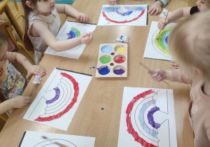 Dzieci malują tęczę.