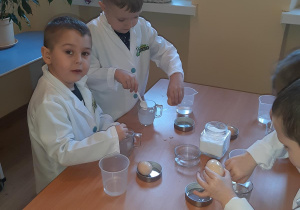 Witek i Olek wsypują sól do swoich szklanek.