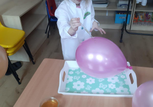 Kornelia polewa balon wybranym sokiem.