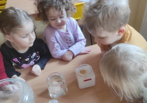 Dzieci w laboratorium przedszkolnym prowadzą eksperymenty - W jakiej wodzie jajko pływa na powierzchni a w jakiej tonie?