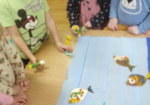 Dzieci wykonały kolorowe rybki a następnie umieszczały je w czystej części wyklejonego jeziora.