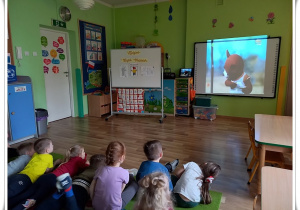 Dzieci oglądają bajkę pt. "Miś Uszatek"