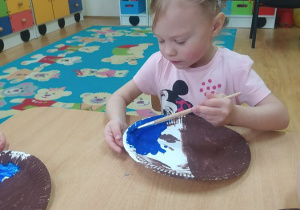 Nikola maluje papierowy talerzyk