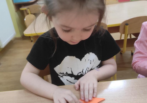 Ada składa tulipana techniką origami.