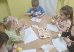 Dzieci malują styropianowe jajka.
