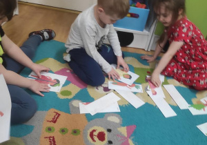 Dzieci układają puzzle z owoców i warzyw.