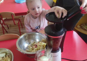 Dzieci pomagają przy robieniu soku jabłkowego.