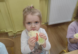 Oliwia zjada swoją kanapkę.