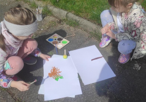 Dziewczynki podczas malowania drzewa.