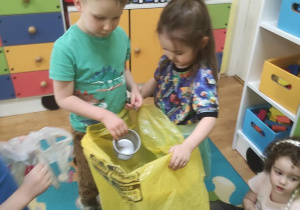 Dzieci ćwiczą jak prawidłowo segregować śmieci.