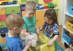 Dzieci ćwiczą jak prawidłowo segregować śmieci.