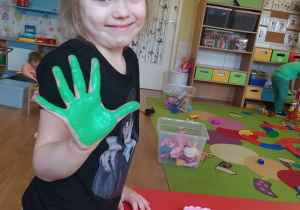 Ada odciska rękę pomalowaną zieloną farbą, która później zostanie wykorzystana jako liść