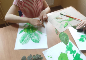 Dzieci odciskają okazy przyrody tworząc własne kompozycje.