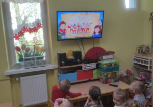 Dzieci oglądają film edukacyjny o symbolach narodowych