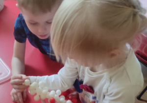 Dzieci układają z klocków flagę Polski