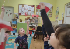 Dzieci machają własnoręcznie przygotowanymi flagami
