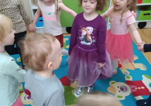 Dzieci stoją w kole i śpiewają Lili "100 lat!"