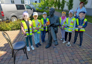 Dzieci stoją przy pomniku Antoniego Troczewskiego