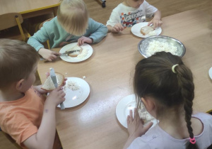 Dzieci przygotowują kanapki z twarożkiem i szczypiorkiem.