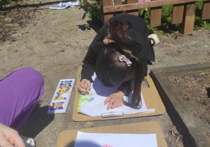 Dzieci obserwują a następnie malują ogród kwiatowy.