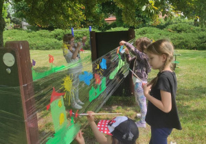 Dzieci malują na folii.