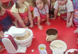 Dzieci oglądają jak mieszają się produkty w robicie.
