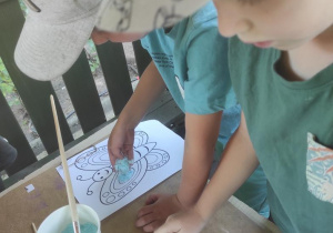 Dzieci podczas malowania motyli.