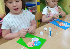 Dzieci przyklejają figury geometryczne tworząc z nich lody.