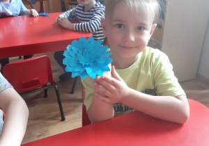 Mateusz prezentuje swój kwiat- wycinankę.