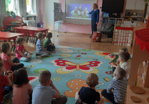 Dzieci oglądają prezentację multimedialna na temat folkloru łęczyckiego i łowickiego.