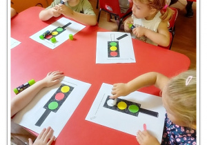 Dzieci przyklejają elementy sygnalizacji świetlnej