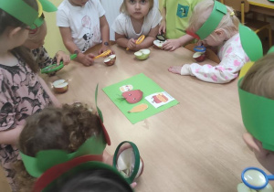 Zabawa badawcza- dzieci oglądają jabłko za pomocą lupy.