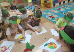 Dzieci wyklejają jabłko plasteliną.