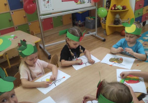 Dzieci wyklejają jabłko plasteliną.