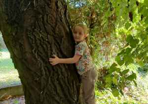 Basia przytula się do drzewa