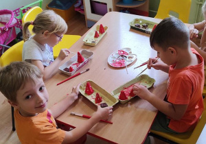 Dzieci malują farbami kolorowe kapelusze grzybków