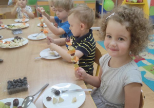 Dzieci robią owocowe szaszłyki.